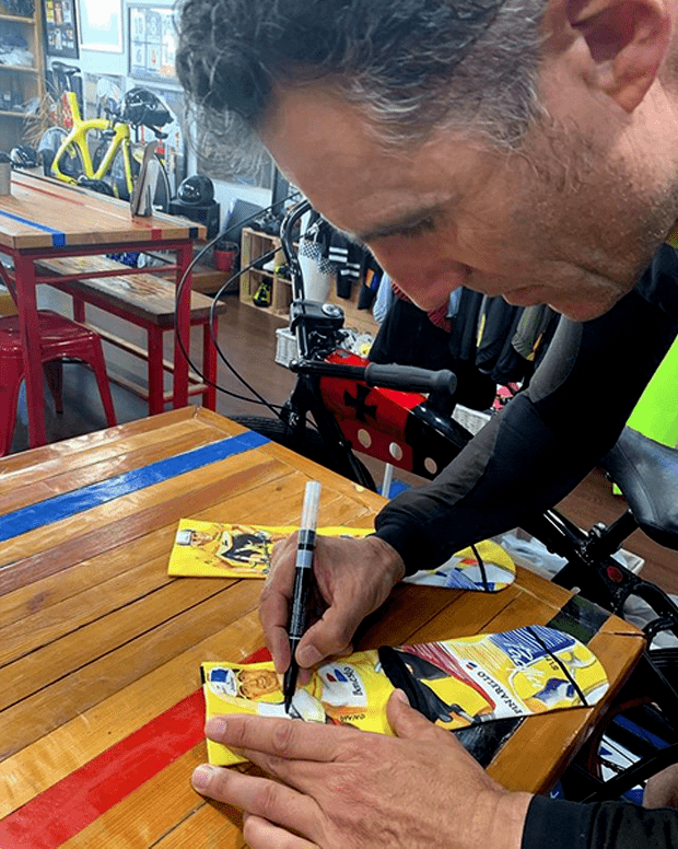 Miguel Indurain firmardo unos calcetines ilustrados por JotaErre “Str8 Visual Dopeness”